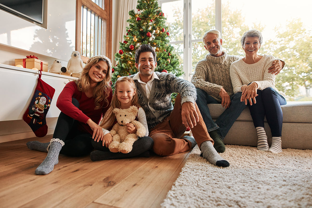 A family portrait of three generations in front of a Christmas tree | Motif