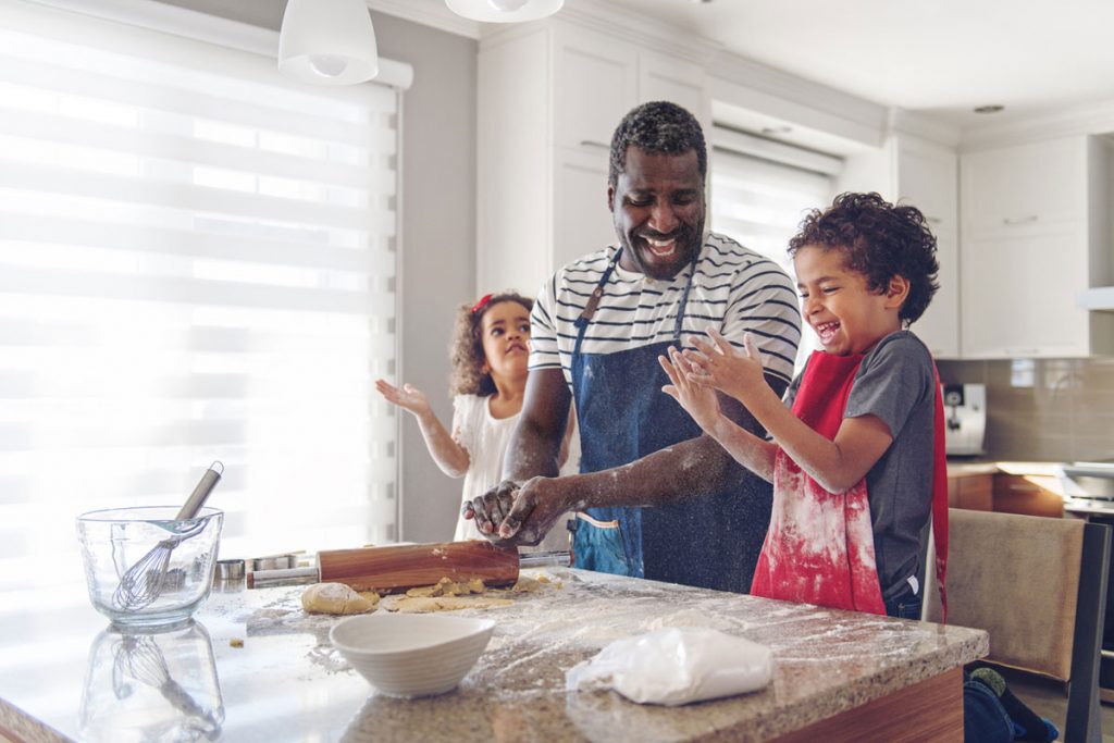 A father and his two kids baking in the kitchen | Motif