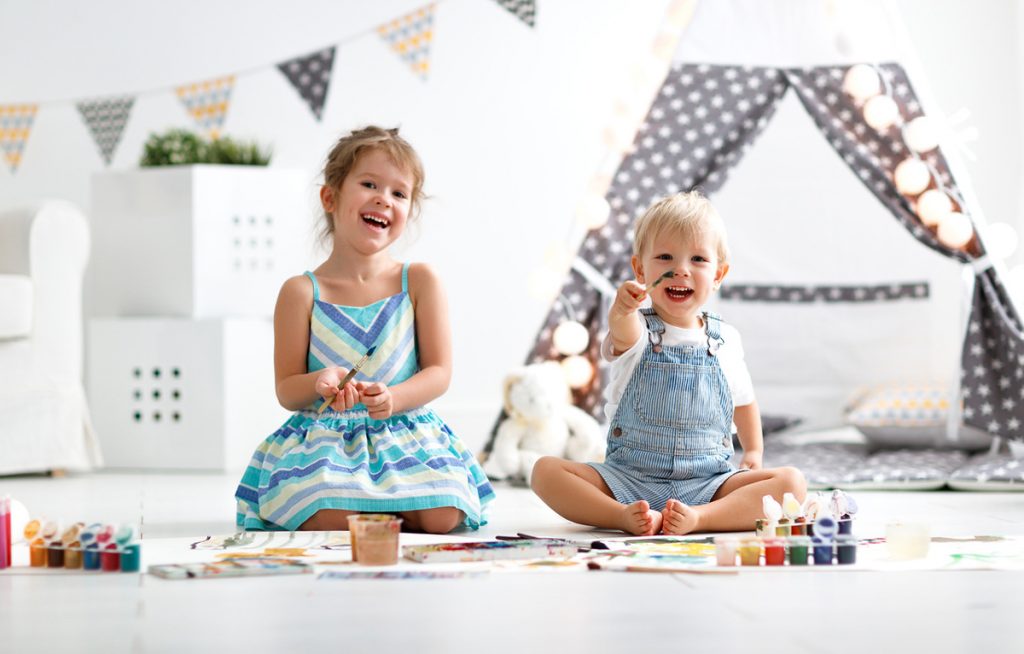 Two children painting in their playroom | Motif