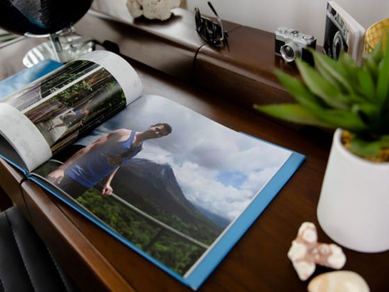 A custom photo book on a wood table with a picture of a man standing in front of a mountain | Motif