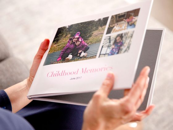 A person holding a custom photo book | Motif