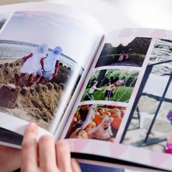 Someone looking through a customer photo book of their children | Motif