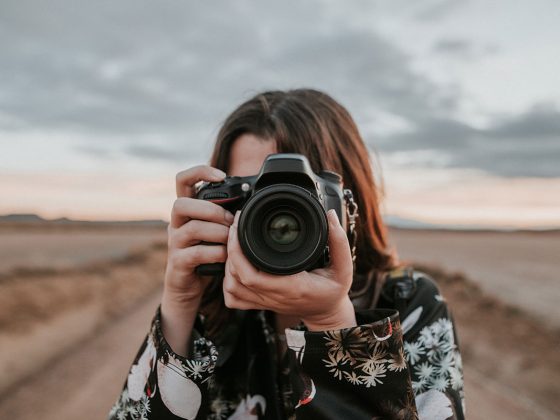 A woman taking a picture with a DSLR camera | Motif