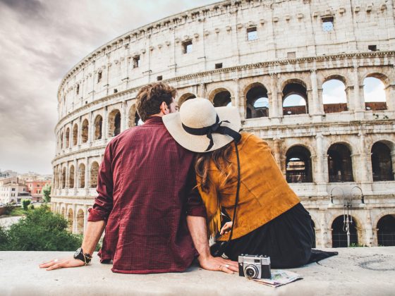 A couple sitting together outside the Roman Colosseum | Motif