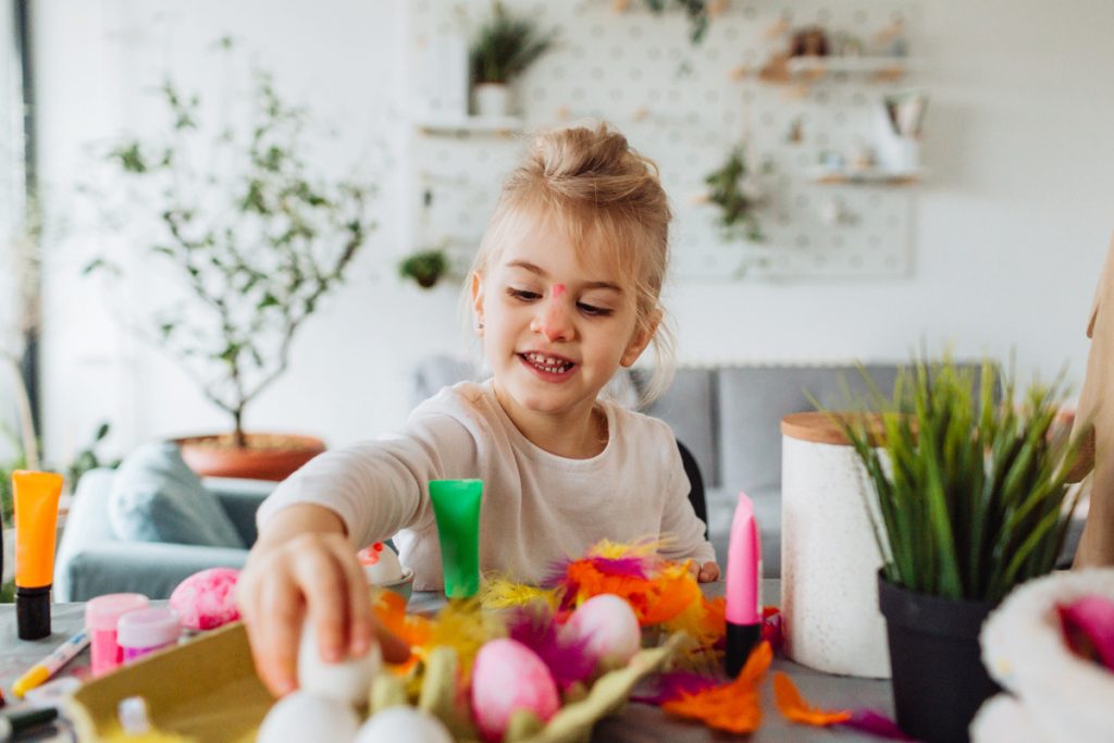 A little girl decorating Easter eggs | Motif
