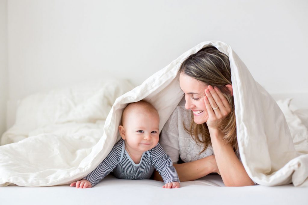 Mom and baby play under a blanket | Motif