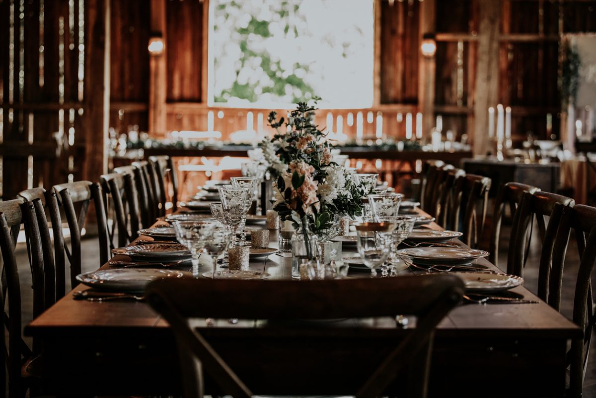 A long table with glassware and flowers on top | Motif