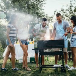 Photography of a group of friends around a grill at a BBQ | Motif