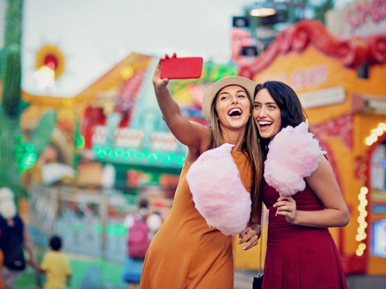 Girlfriends taking selfie at a summer carnival