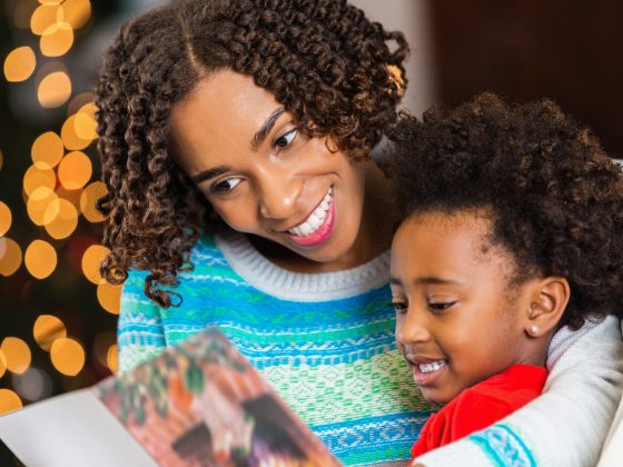 Mom reading Christmas card to daughter at home