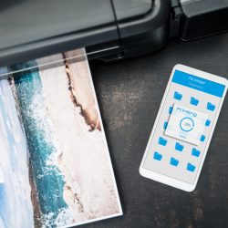 Smartphone connected to the wireless printer is laying on the desk