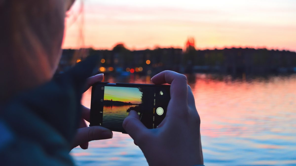 Taking a picture of the sunset over water on an iPhone | Motif