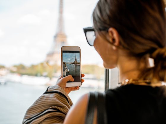 Woman photographing eiffel tower in Paris