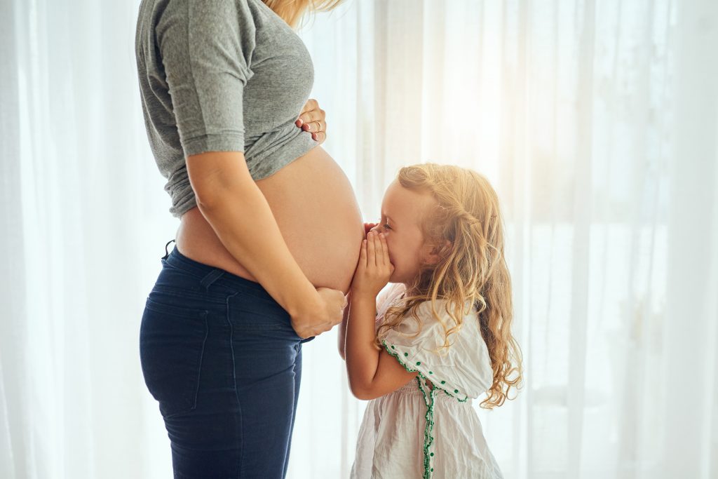 Big sister kissing the bump our moments to add to your pregnancy memory book.