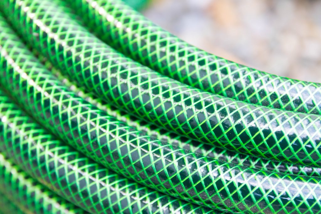 Think abstract with contrasting color photography by snapping a closeup of bright green water hose.