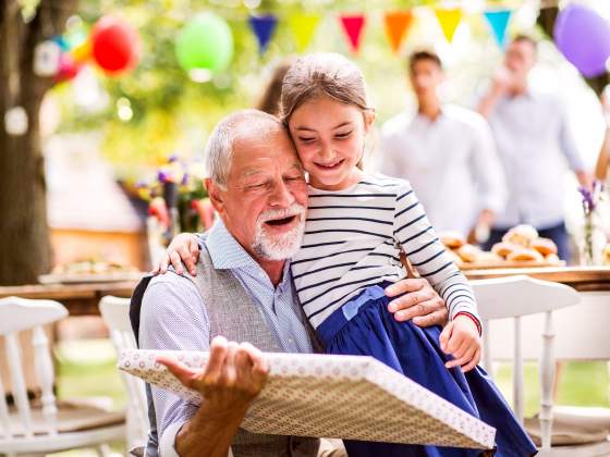 Grandpa and granddaughter celebrating a birthday outside is the perfect photo book idea.