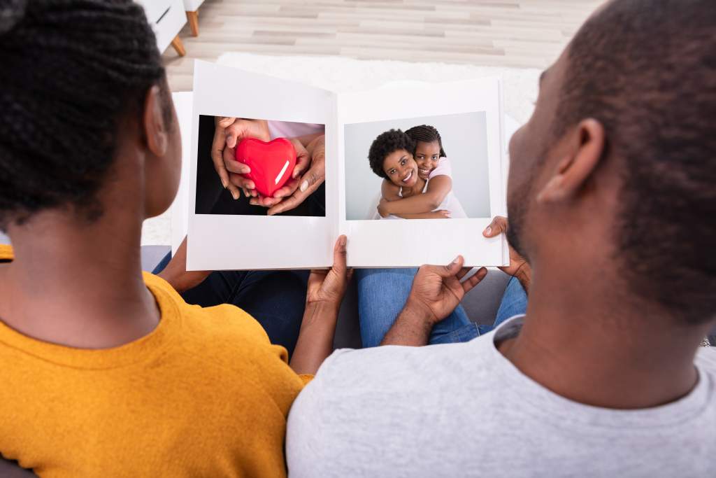 African American couple looks at the Motif photo album they created using Apple Photo tips.