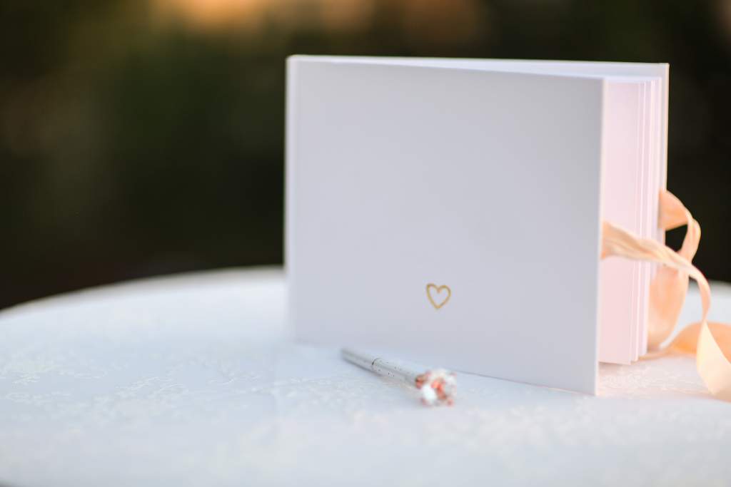 A white Apple photo book with gold lettering works well as a wedding guestbook.