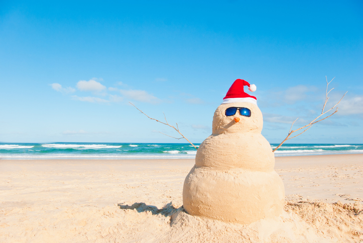 Need sunny Christmas card ideas? Build a sandman on beach with twig arms, sunglasses & Santa hat.