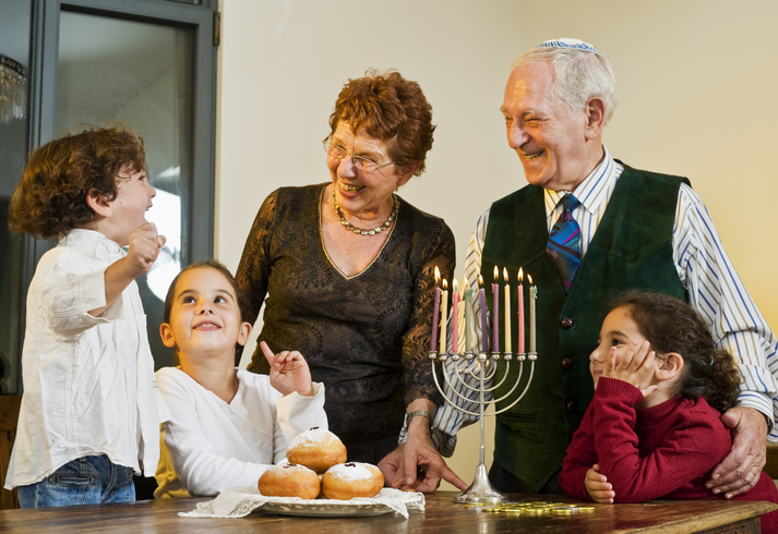 Jewish kids with grandparents around menorah makes for a precious Hanukkah greeting card.