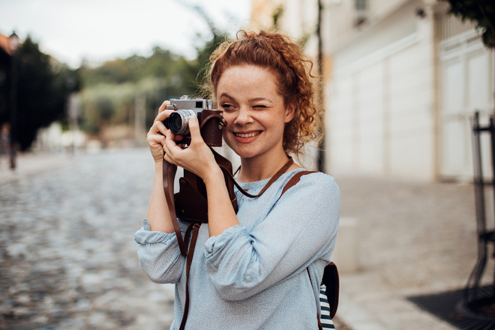 Redhead uses camera and other photography gifts she received to take pictures.