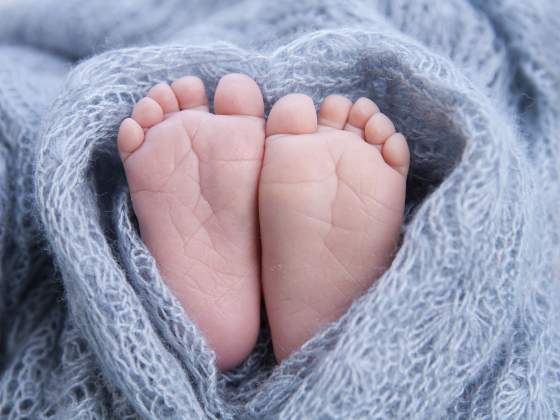Easy newborn photography ideas include close-ups of tiny feet and soft blankets.