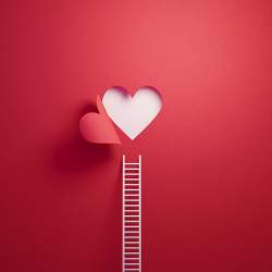 White Ladder Leaning on Red Wall with Cut Out Heart Shape