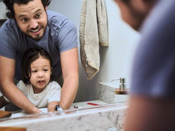 Young dad and cute son washing hands in the bathroom