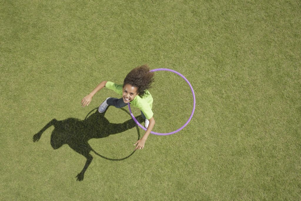 Young girl playing with hula hoop