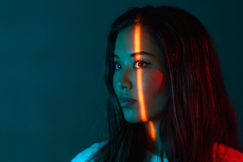 Portrait of beautiful woman lit by neon colored lights